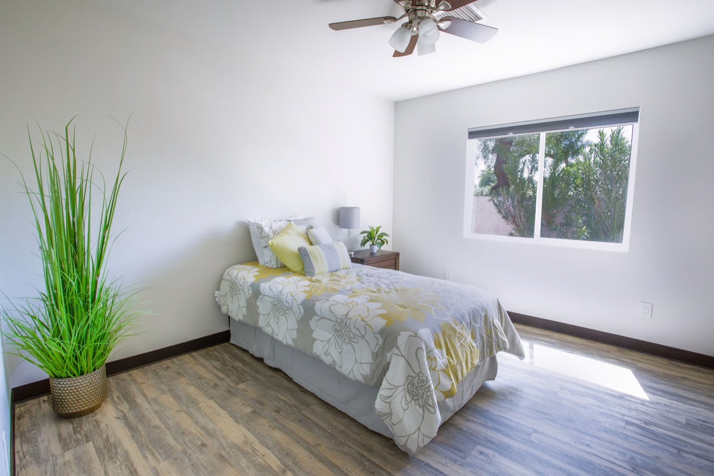 Furnished resident bedroom with a garden-view window at McCormick Ranch Assisted Living